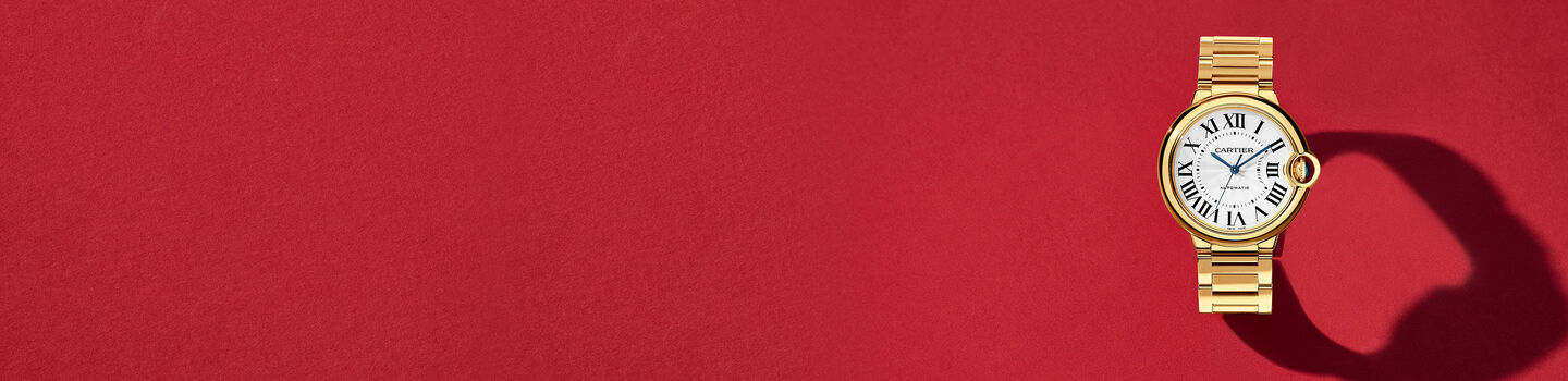 Gold Ballon Bleu de Cartier watch on a red background.