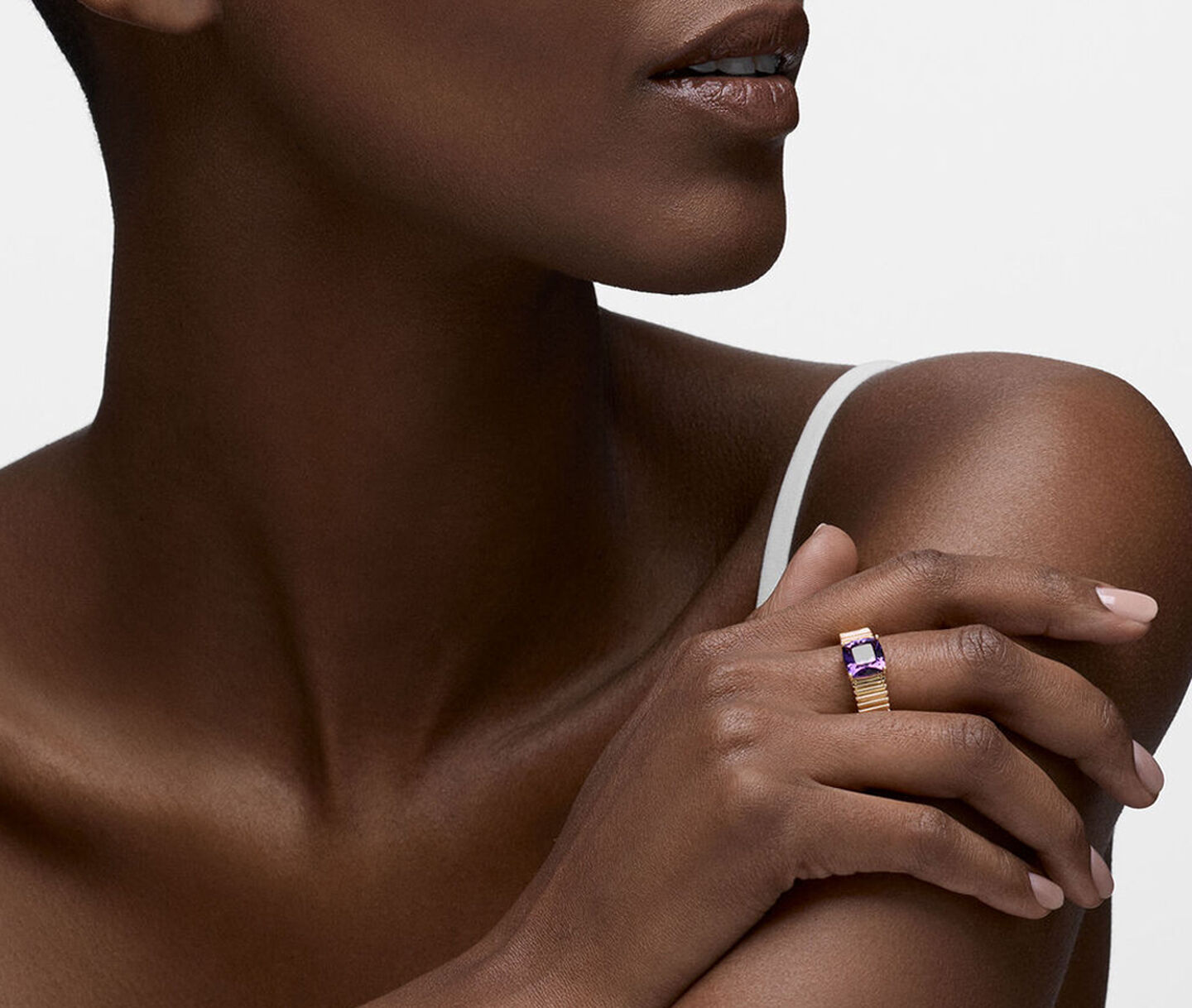 A woman wearing a Birks Essentials gold and amethyst ring.
