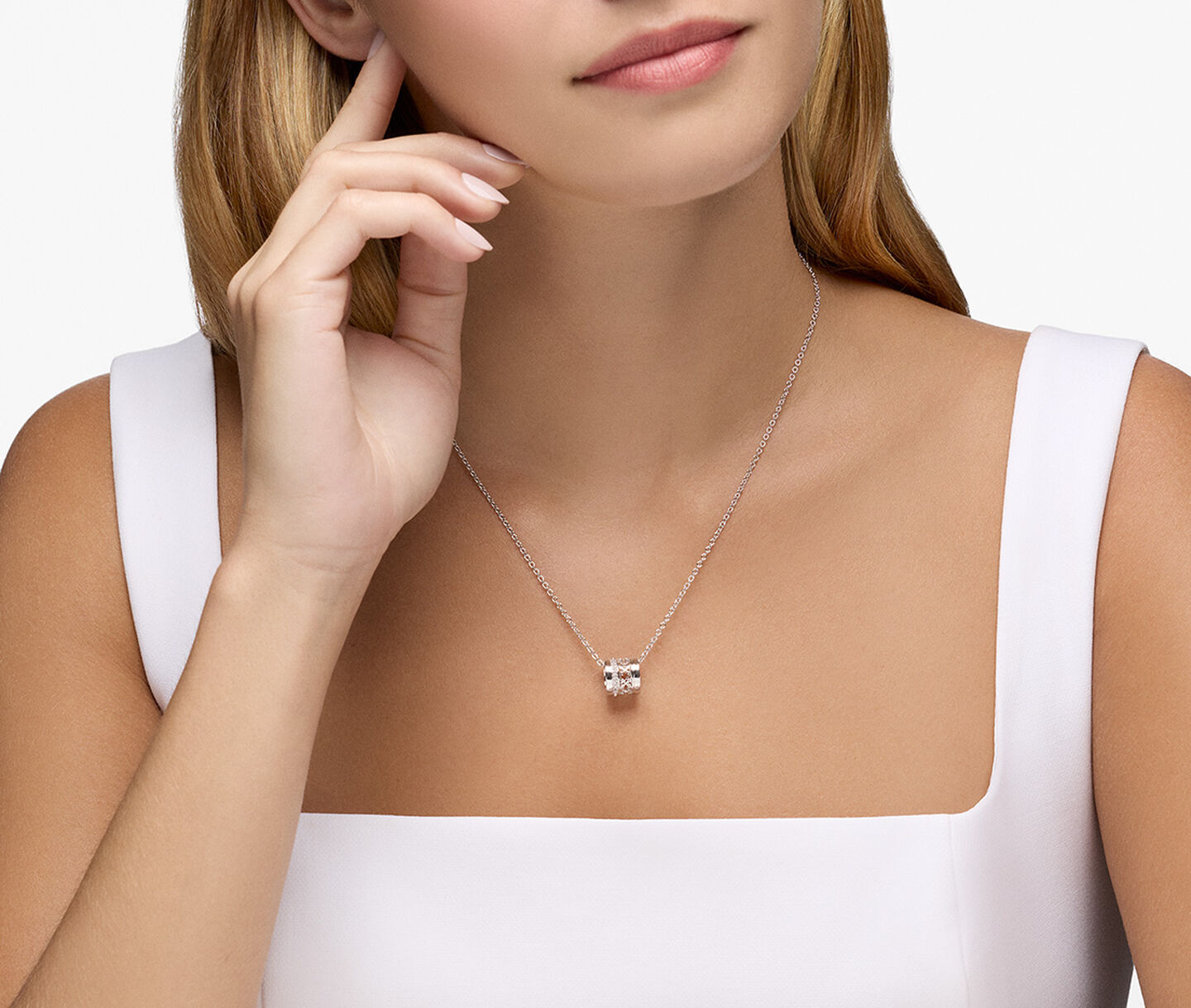 A woman wearing a Birks Dare to Dream silver pendant.