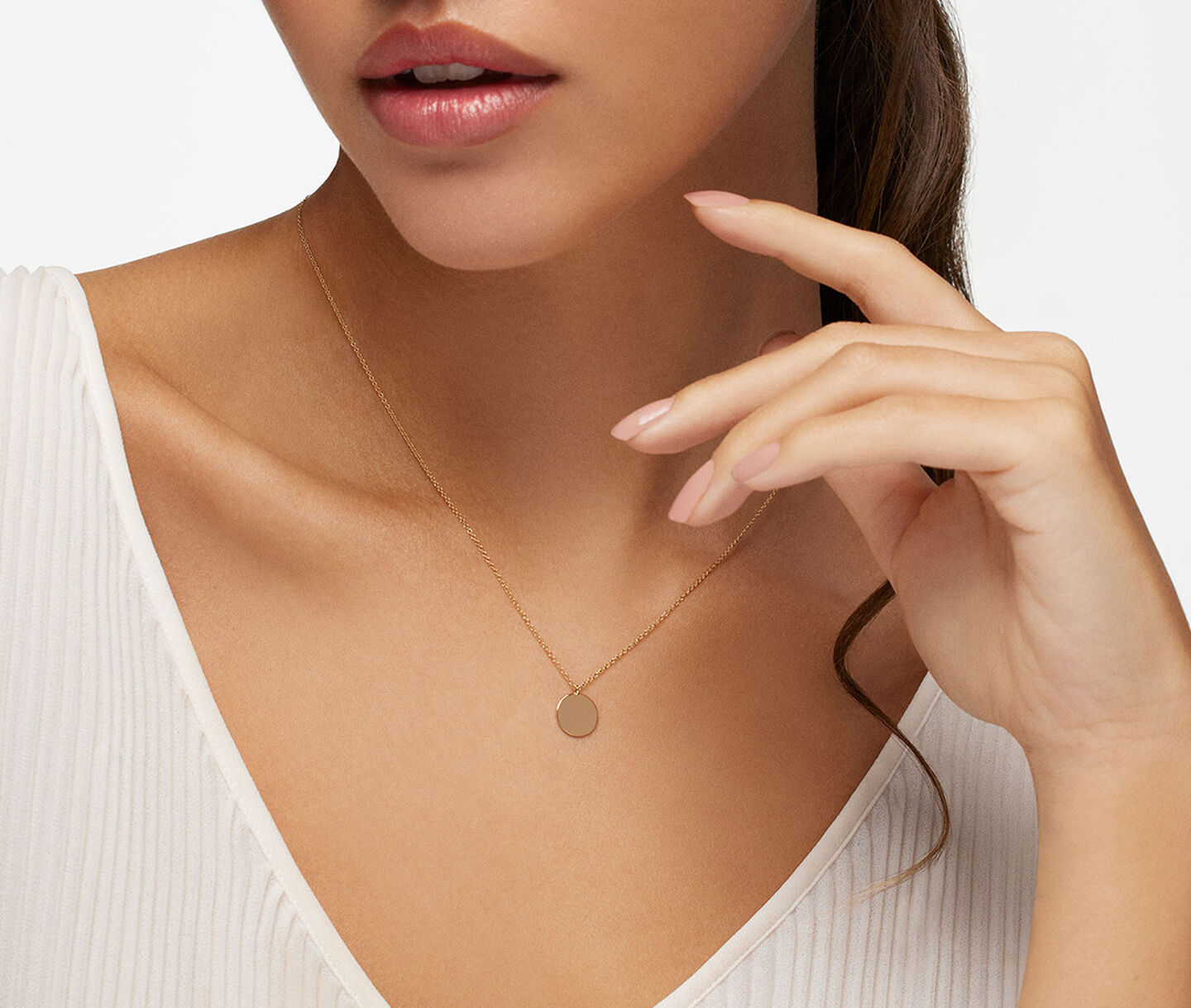 A woman wearing a Birks Essentials gold necklace.
