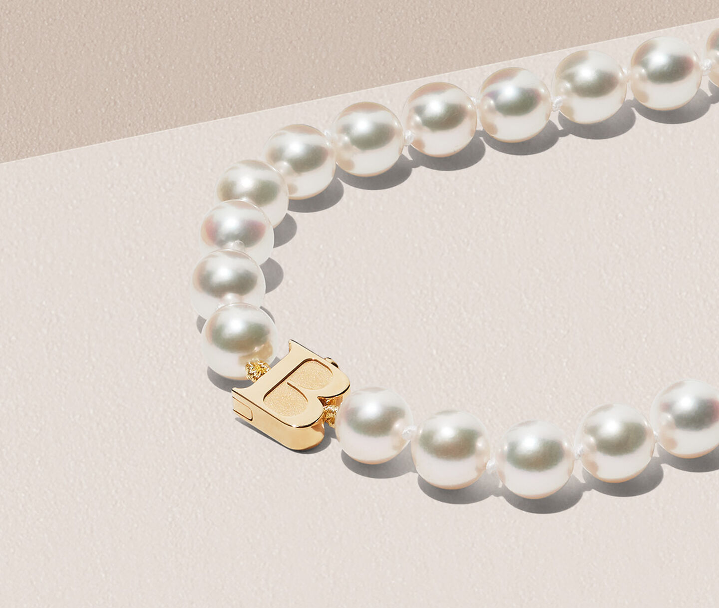 Birks Pearls Akoya necklace on a beige background.