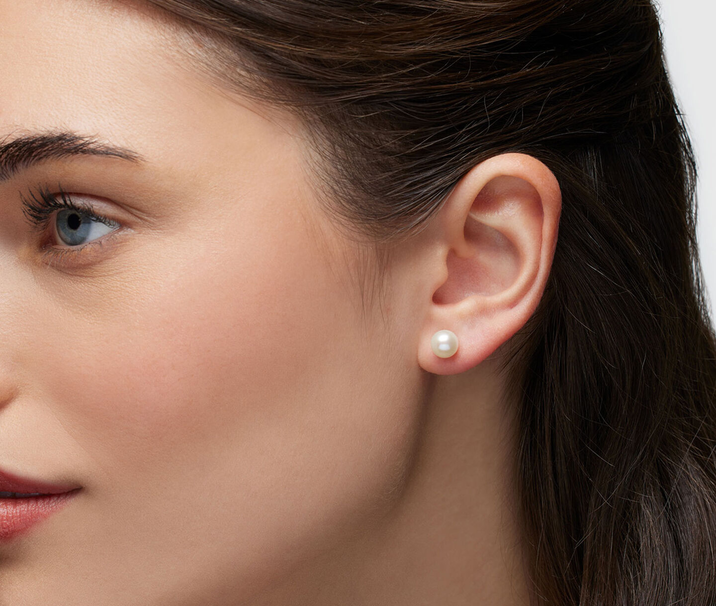 A woman wearing Birks Pearls earrings.