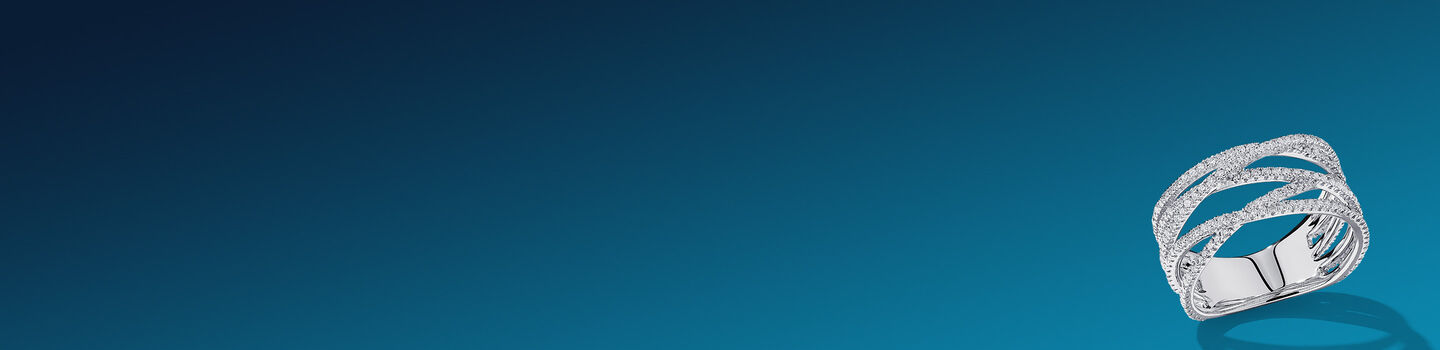 Birks Ros&eacute;e du Matin white gold and diamond ring on a dark blue background.