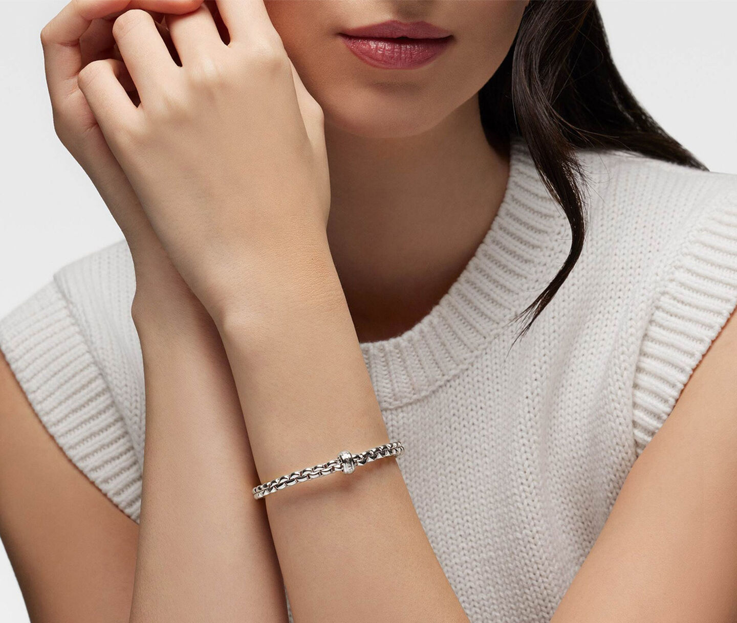 A woman wearing a FOPE white gold and diamond bracelet.