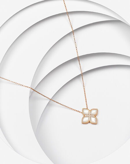 A rose gold and mother of pearl Roberto Coin Princess Flower pendant on a white layered background.
