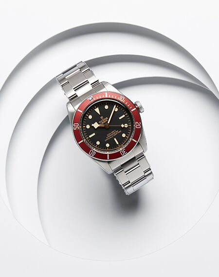 A TUDOR watch for men on a white layered background.