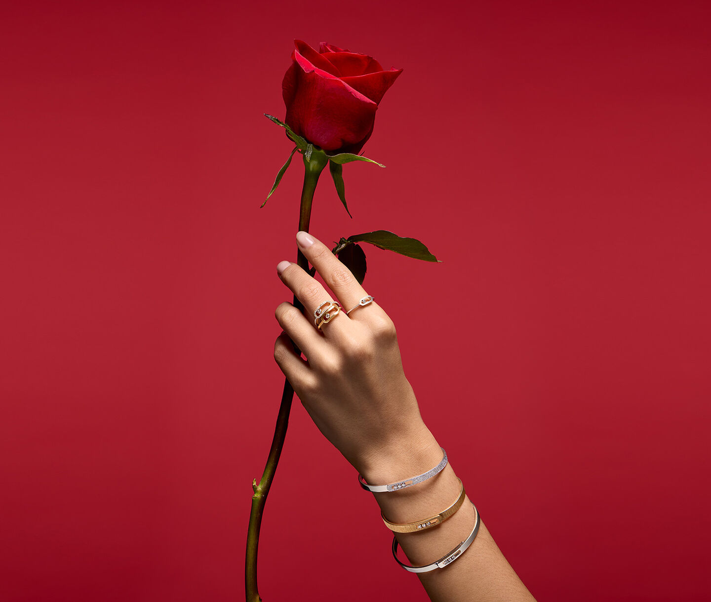 A woman wearing Messika jewellery on red background.