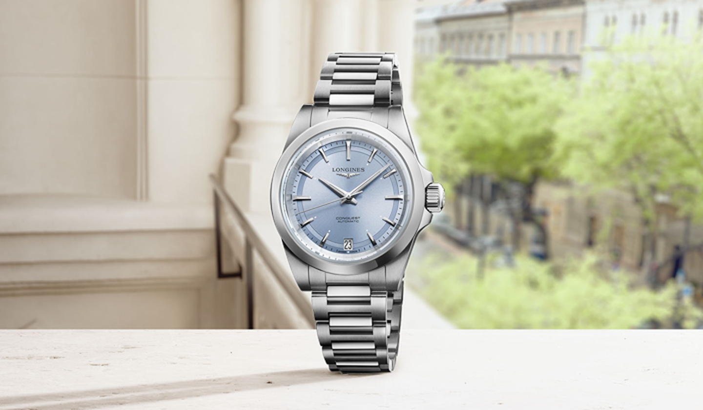 Longines conquest on a beige and green background.