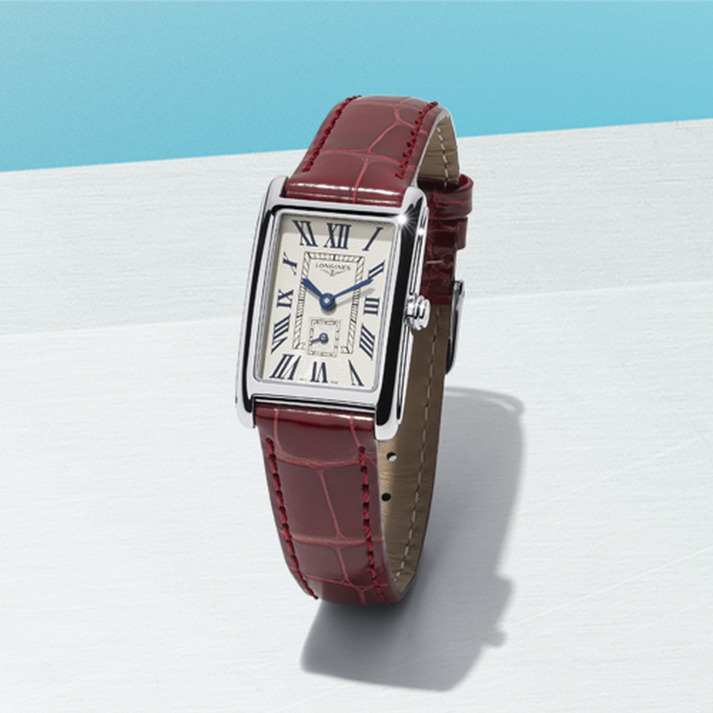 Longines DolceVita watch on a light blue background.
