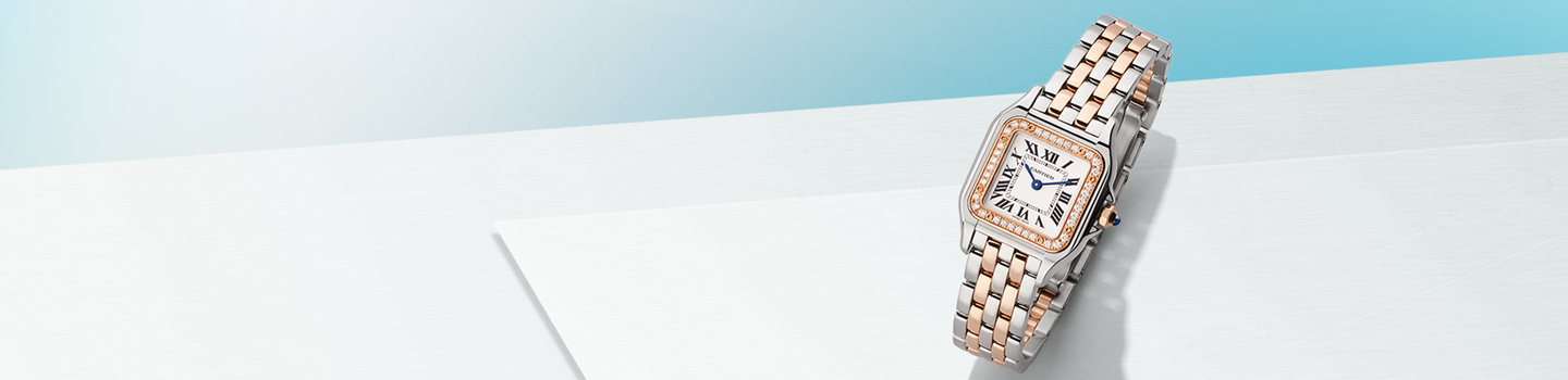 Panthere de Cartier watch on a light blue background.