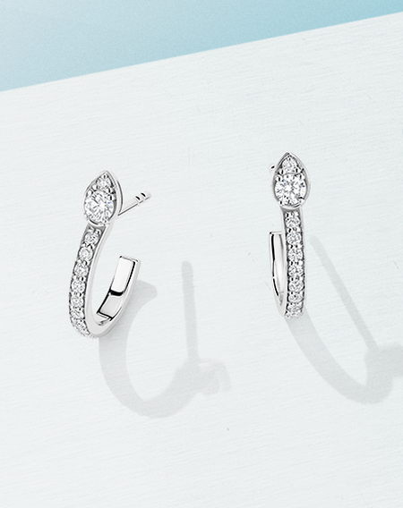 Birks Splash diamond earrings on a blue background.