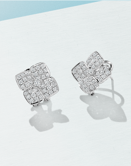 Uneek diamond earrings on a light blue and baby blue background