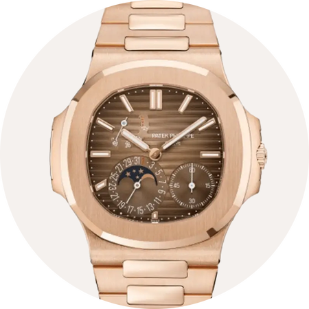 Rose gold Patek Philippe watch on a beige background.