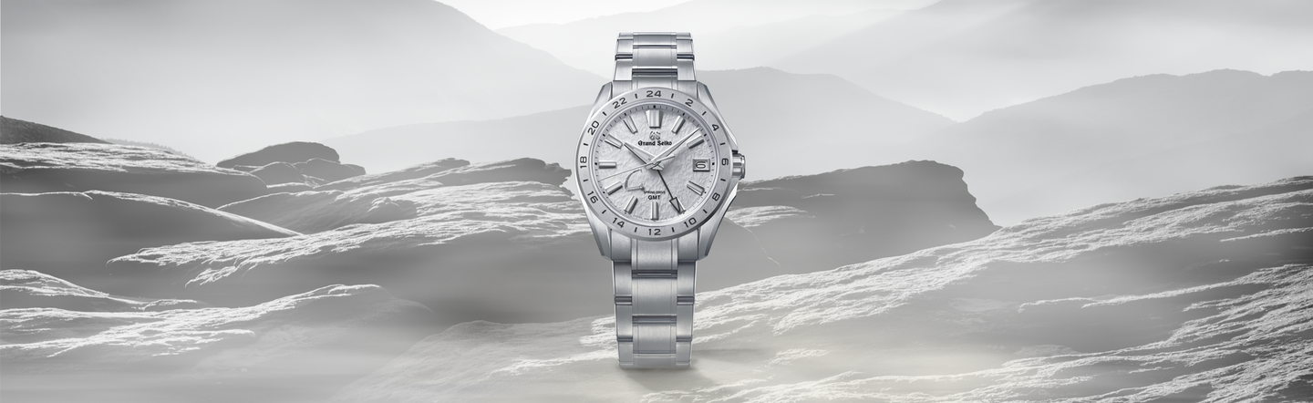 A Grand Seiko watch on a mountainous background.