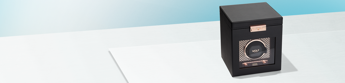 Wolf Axis copper single watch winder on a light blue background.